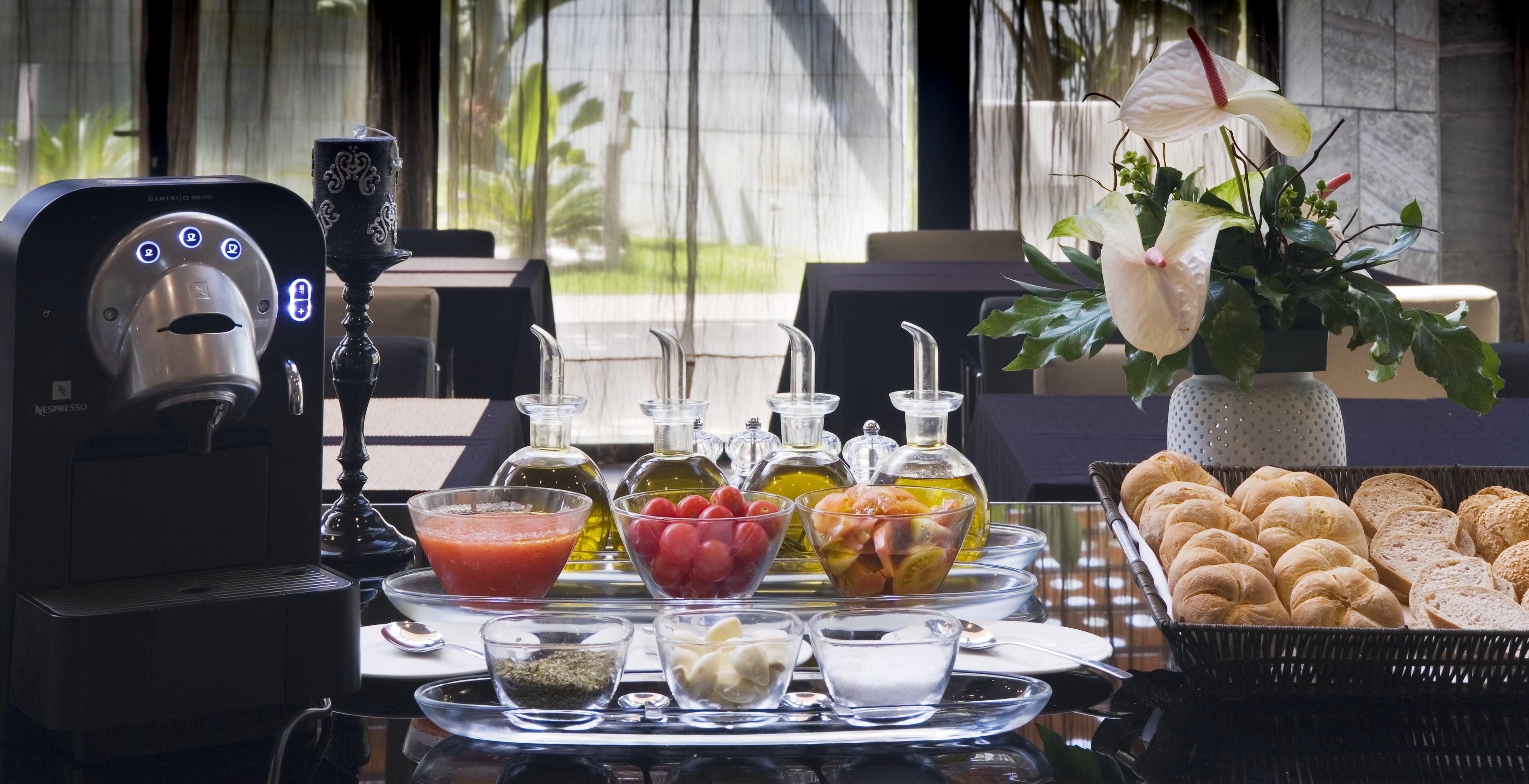 ยูโรสตาร์ส พาเลซ โฮเต็ล Hotel กอร์โดบา ภายนอก รูปภาพ The photo showcases a beautifully arranged dining setting. In the center, there are several glass containers filled with different types of oils, possibly olive oil. Accompanying them are small bowls containing various ingredients, including what app
