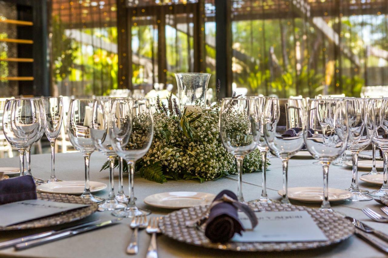 ยูโรสตาร์ส พาเลซ โฮเต็ล Hotel กอร์โดบา ภายนอก รูปภาพ The photo displays an elegantly set dining table arranged for a formal event. The table is adorned with a centerpiece made of white flowers and greenery, surrounded by numerous glassware, including wine glasses and water goblets. Each place setting i